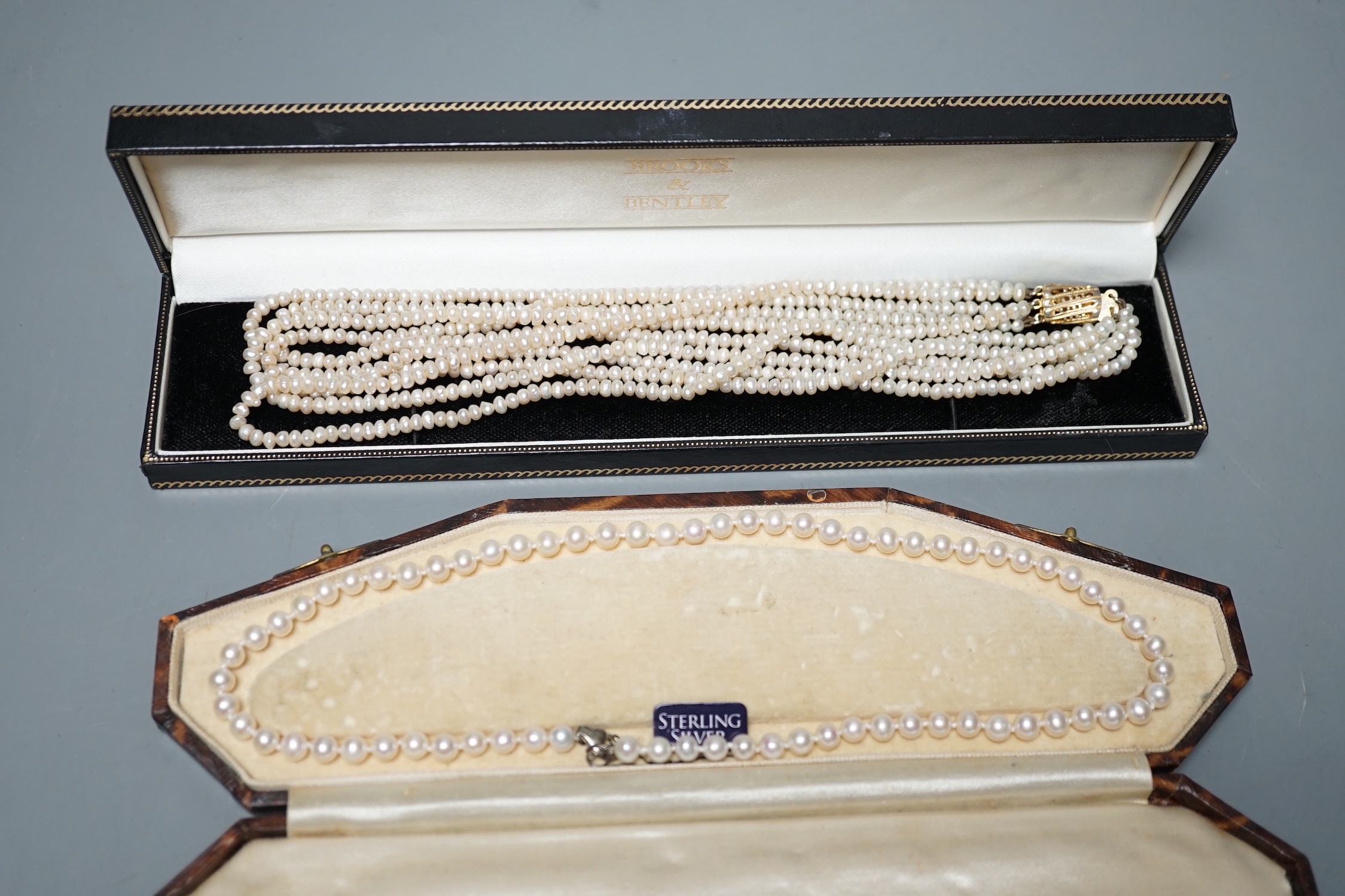 A single strand cultured pearl necklace, with sterling clasp, 44.5cm and a quadruple strand baroque seed pearl necklace, with gilt metal clasp, 42cm.
